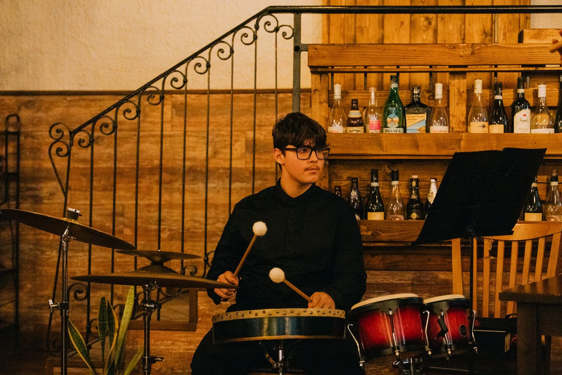 Il giovane percussionista al tamburo a cornice e ai bonghi