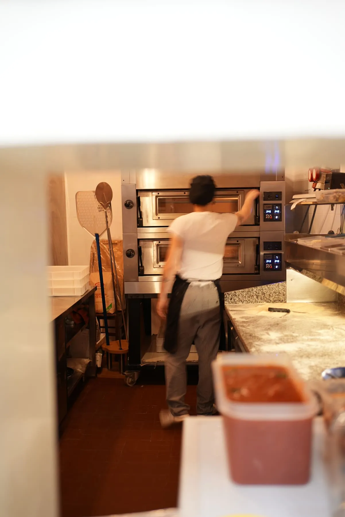 Il pizzaiolo al lavoro davanti al forno