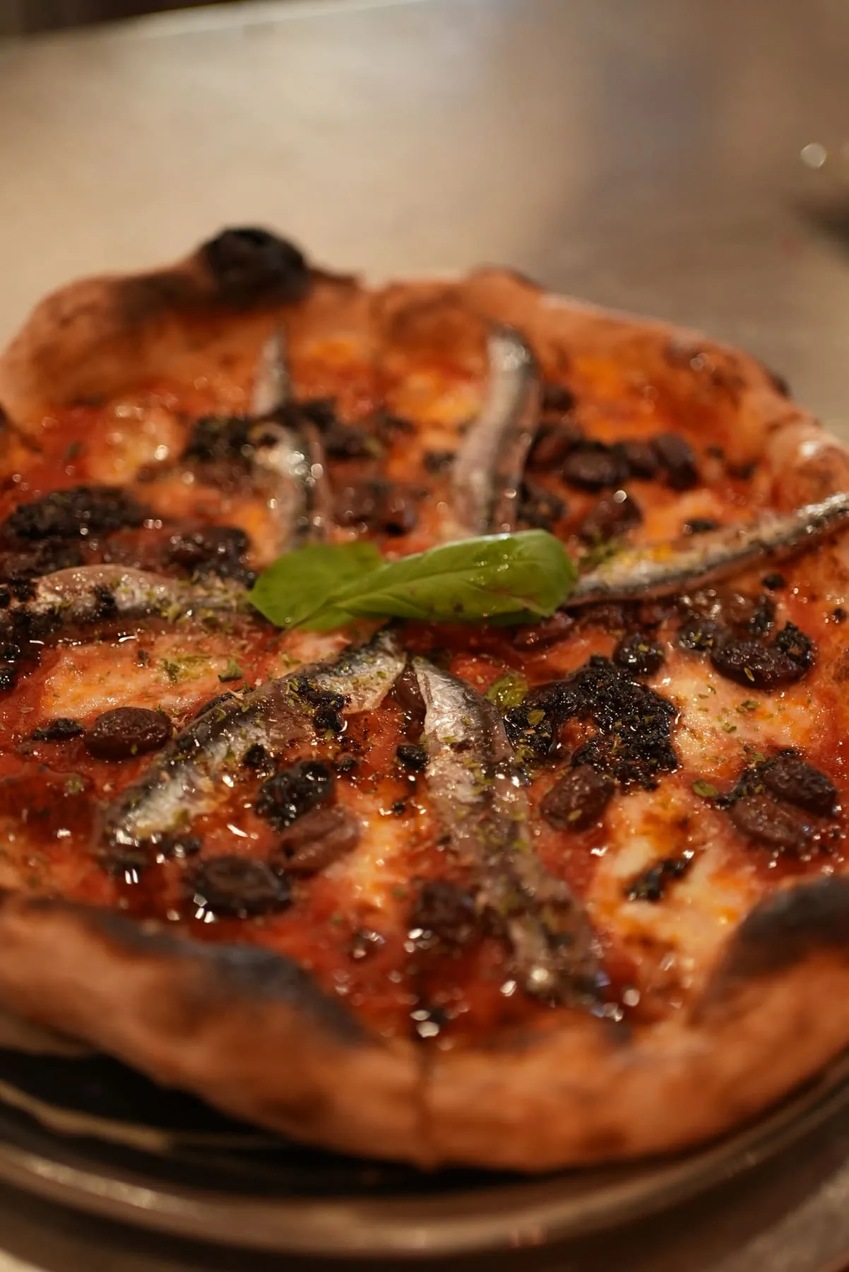 Pizza con acciughe, peperone crusco e basilico