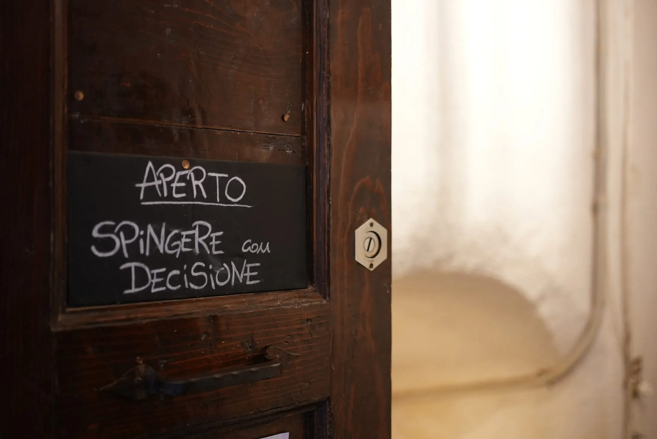 La porta d'ingresso con la scritta a gesso: aperto, spingere con decisione