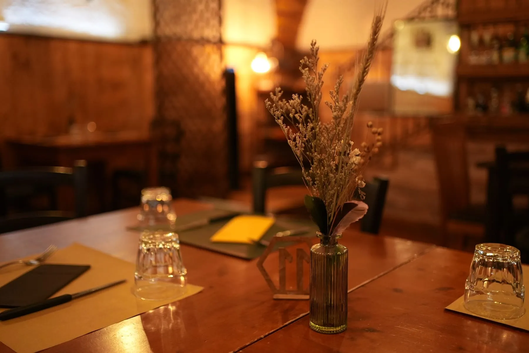 Dettaglio di un tavolo apparecchiato con bicchieri e fiori